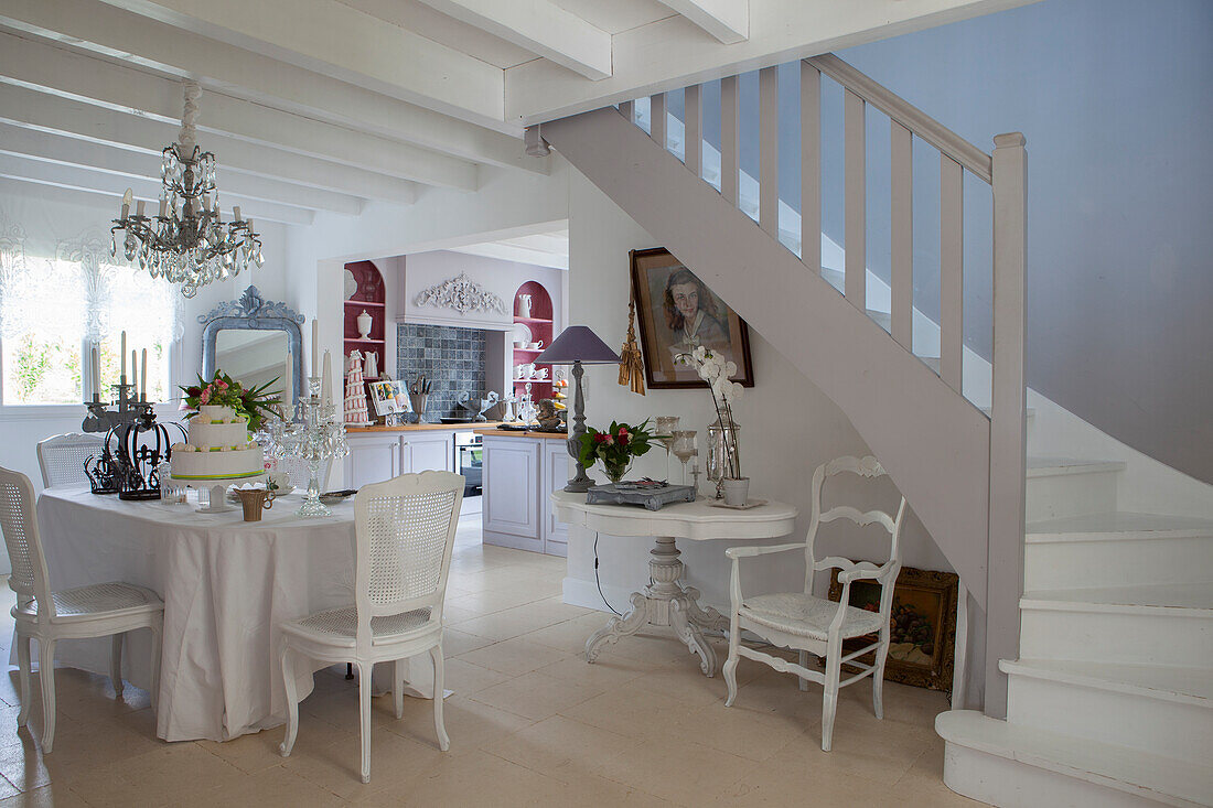 Cake on festively decorated table in open-plan interior with white winding staircase in foreground