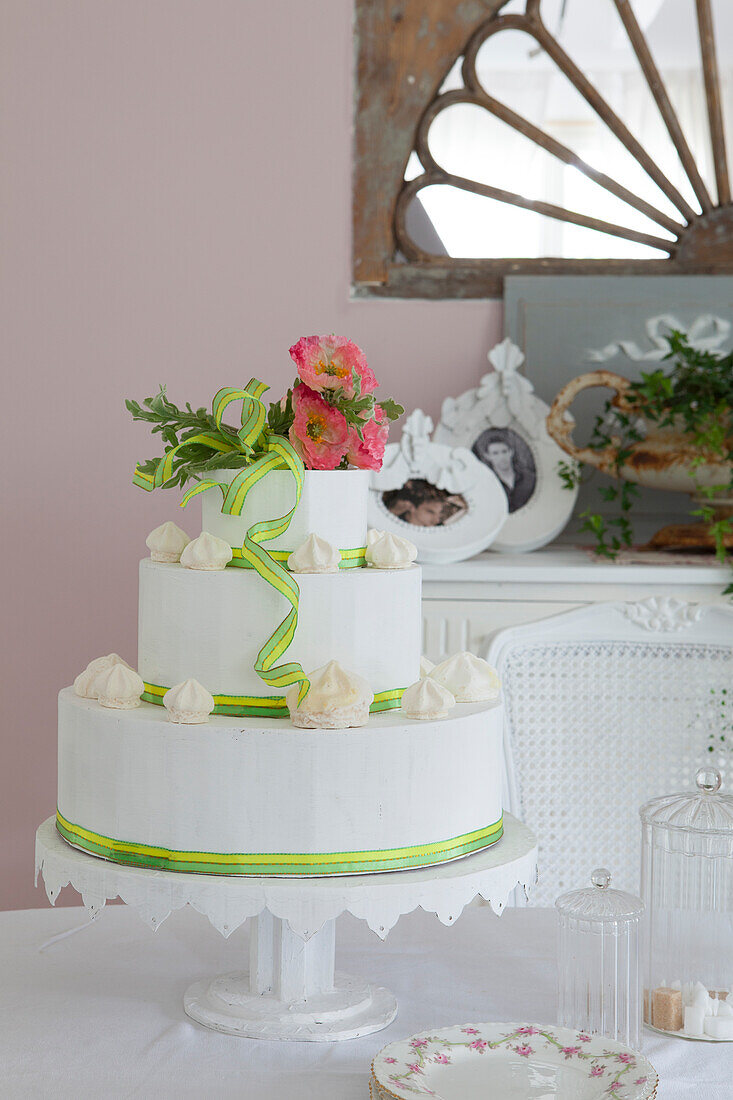 White, decorated three-tier cake with green ribbons