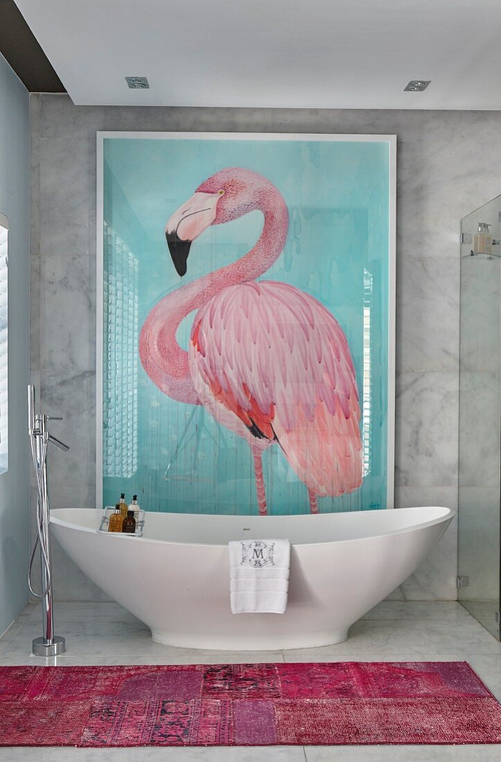 Bild mit Flamingomotiv hinter freistehender Badewanne in Marmorbad