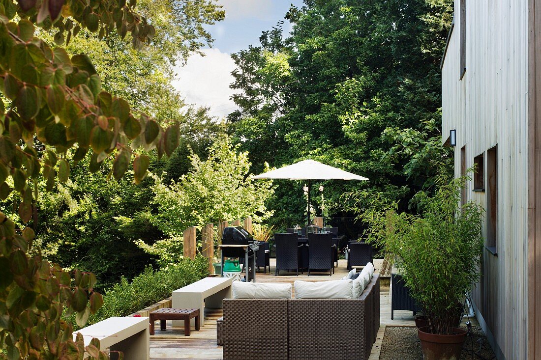 Terrasse mit modernen Outdoormöbeln vor Garten