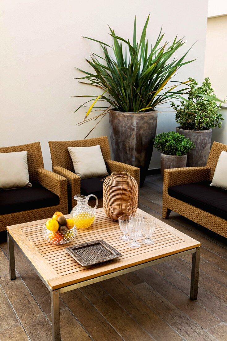 Wicker furniture around coffee table with planters to one side