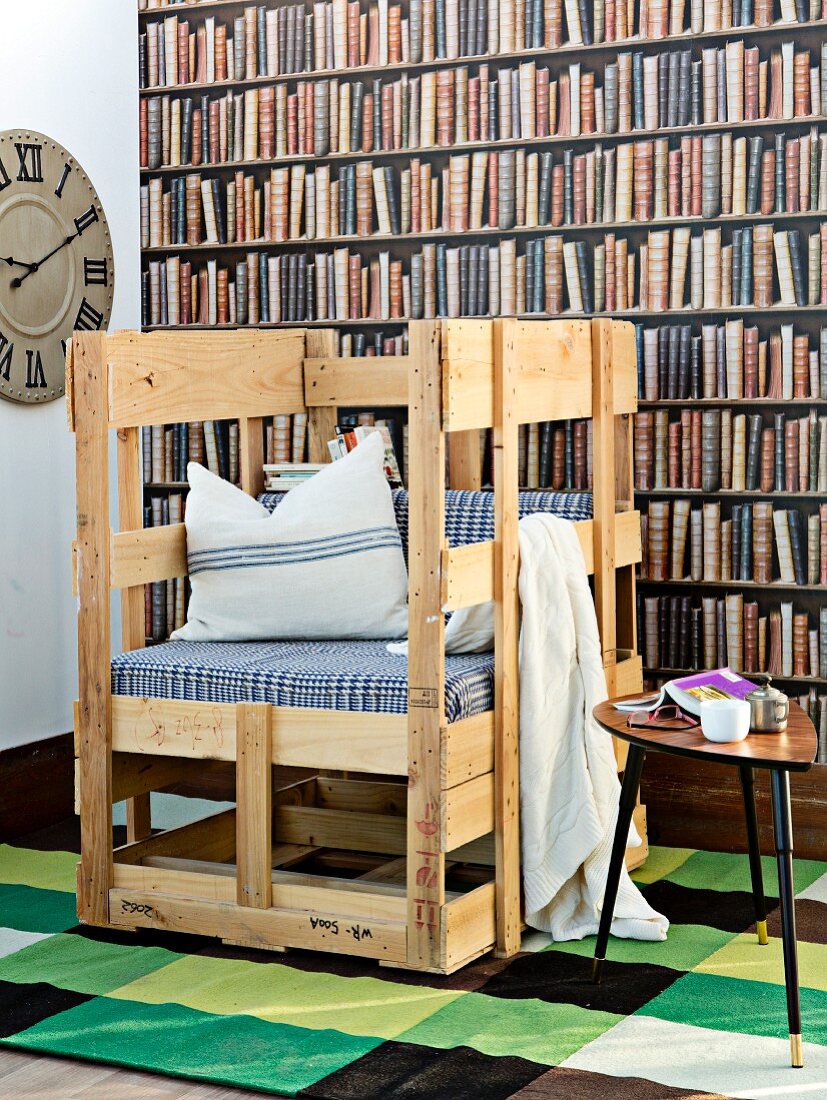 Hand-crafted rustic chair with seat cushion and scatter cushions against photo mural of bookcase