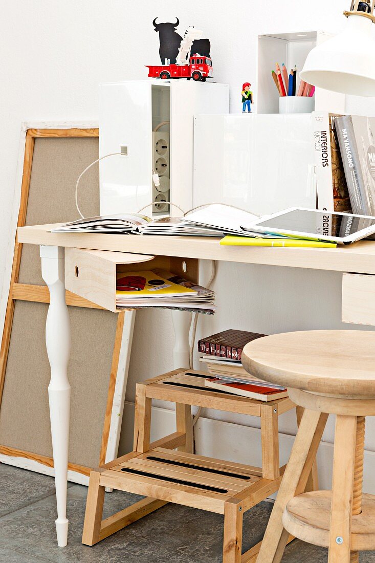 Unter Schreibtischplatte geschraubter Sperrholz-Stehordner als drehbare Stauraumlösung