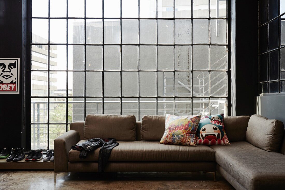 Modern corner couch in front of industrial window