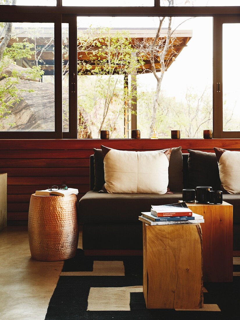 Solid wooden side tables and scatter cushions on sofa in lounge area