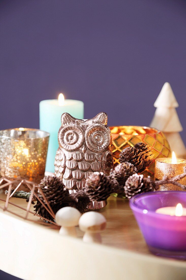 Owl ornament, larch cones, candles and tealight holders