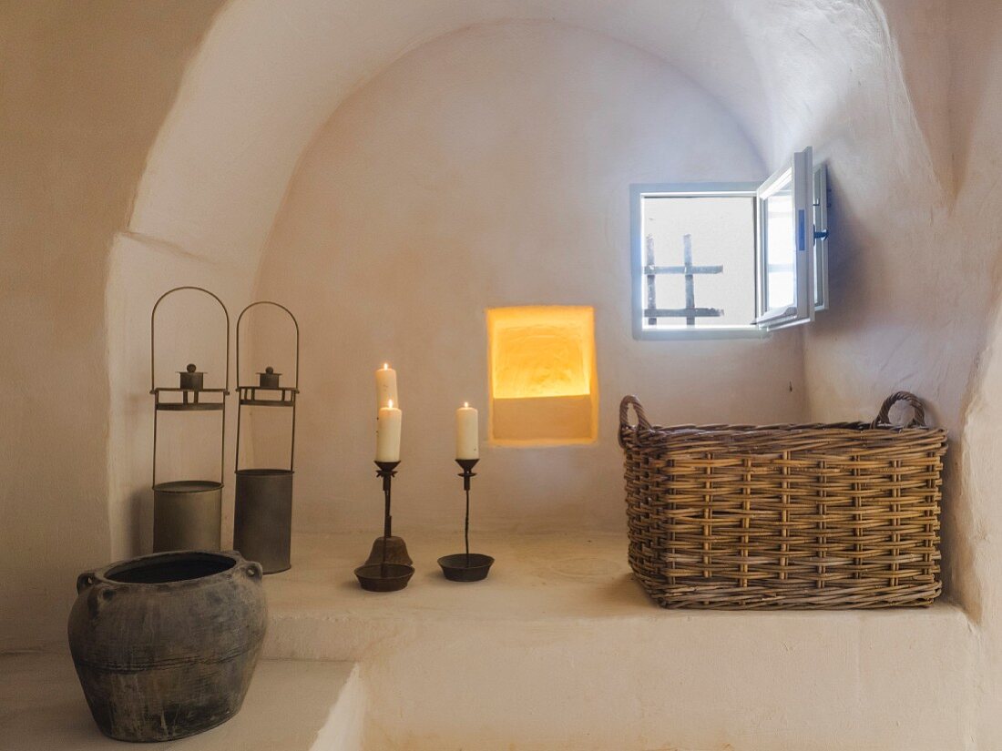 Rustically decorated arched niche with small window in restored Apulian trullo