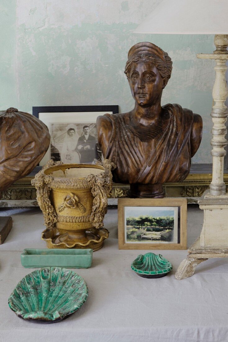 Ceramic ornaments and wooden bust of woman on surface