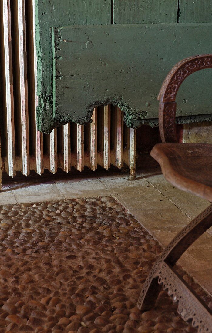 Pebble mosaic floor, carved chair, turquoise vintage board and old radiator