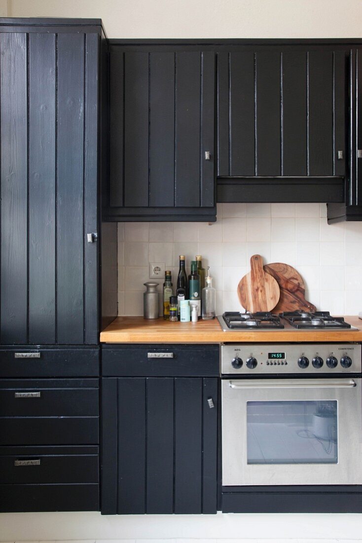 Black country-house kitchen with wooden board doors