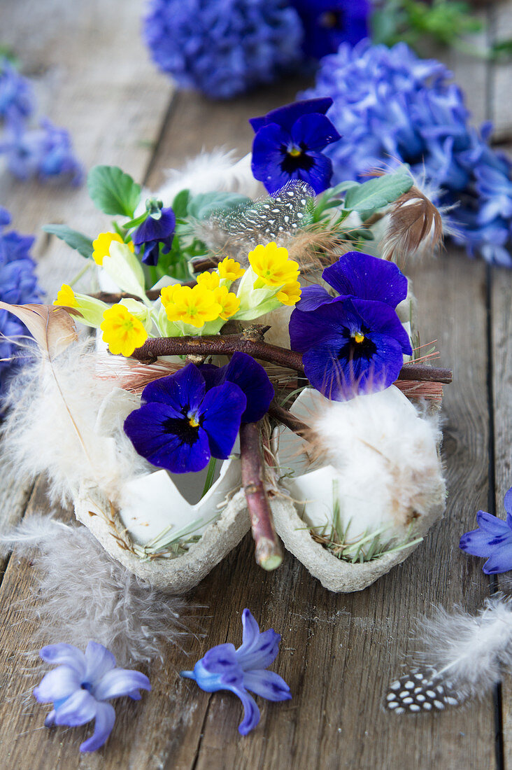 Violas, cowslips and feathers in egg shells