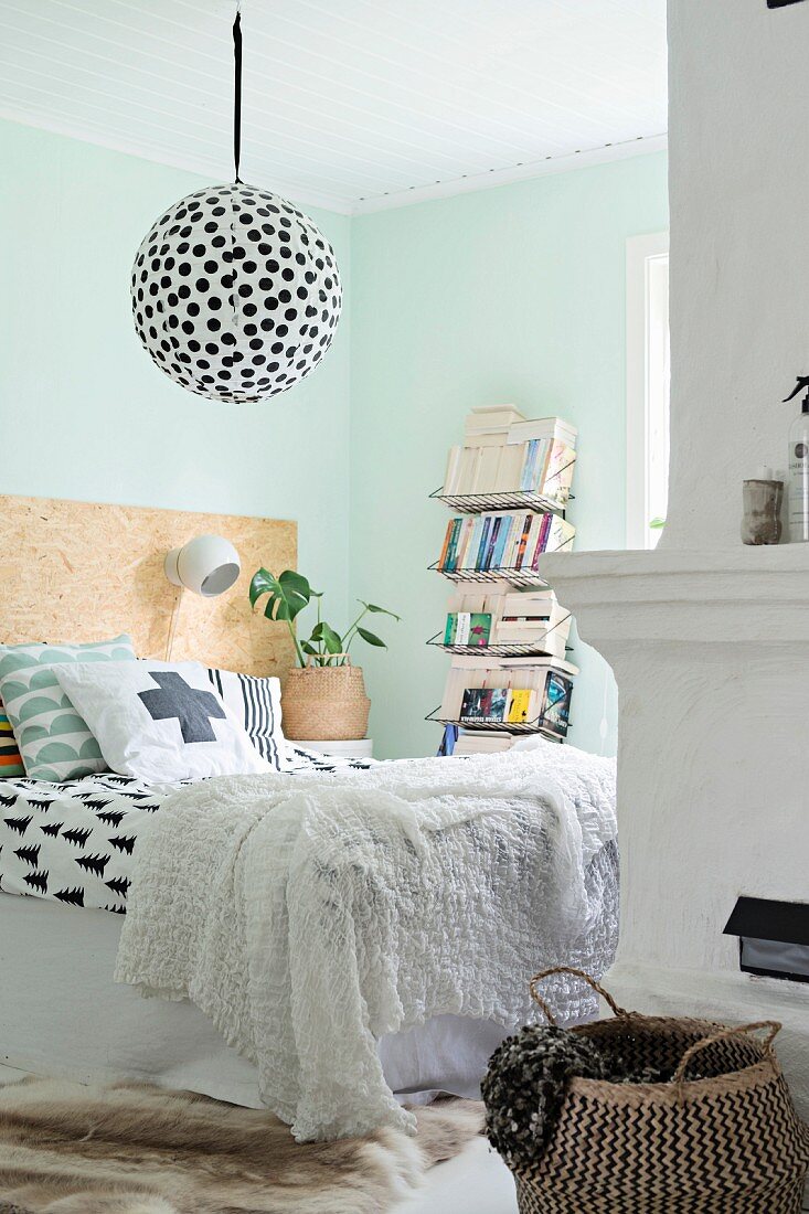 Schlafzimmer mit grafischen Mustern und türkiser Wand