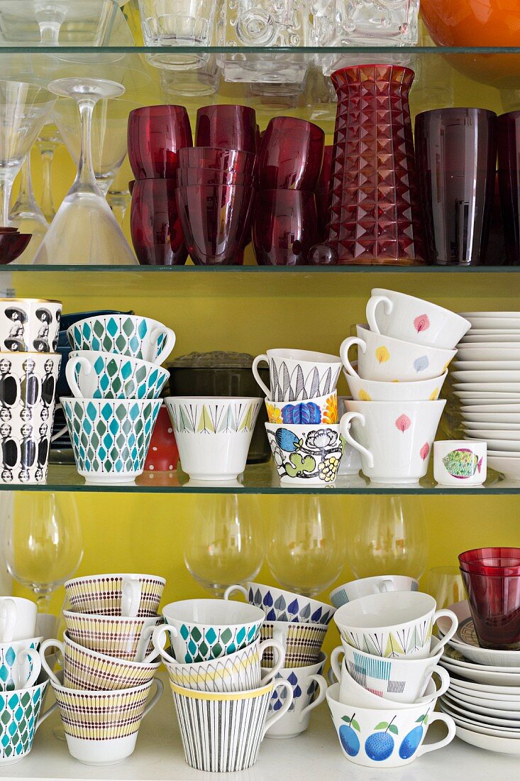 Collection of retro cups and crockery on glass shelves