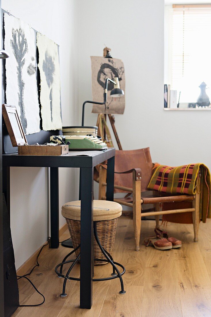 Schwarzer Wandtisch und Sessel mit Leder Sitz- und Rückenfläche in künstlerischer Zimmerecke