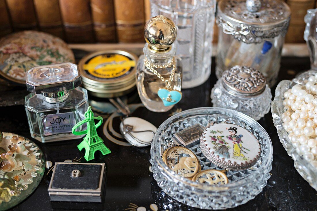 Parfümflakons und Kristallglasschale mit antiken Schmuckstücken und nostalgischem Flair