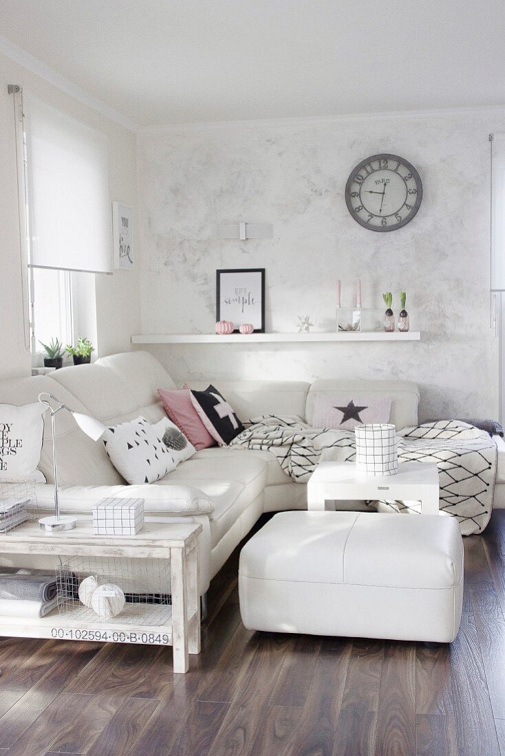 weiße Eckcouch mit passendem Sitzhocker und Shabby Beistelltisch in Wohnzimmerecke