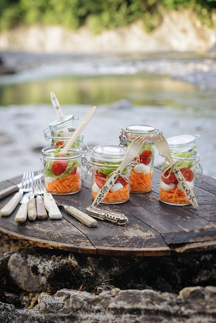 Picknick an Flußufer mit Schichtsalat in Einmachgläsern