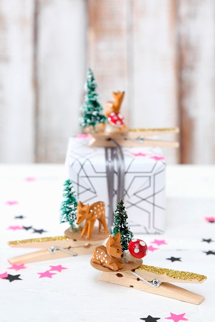 Clothes pegs decorated with tiny deer figurines and Christmas trees