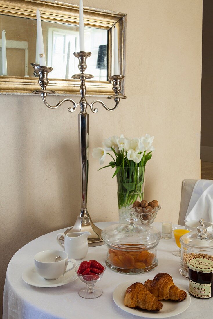 Runder Frühstückstisch mit Silber-Kerzenständer und Tulpenstrauss