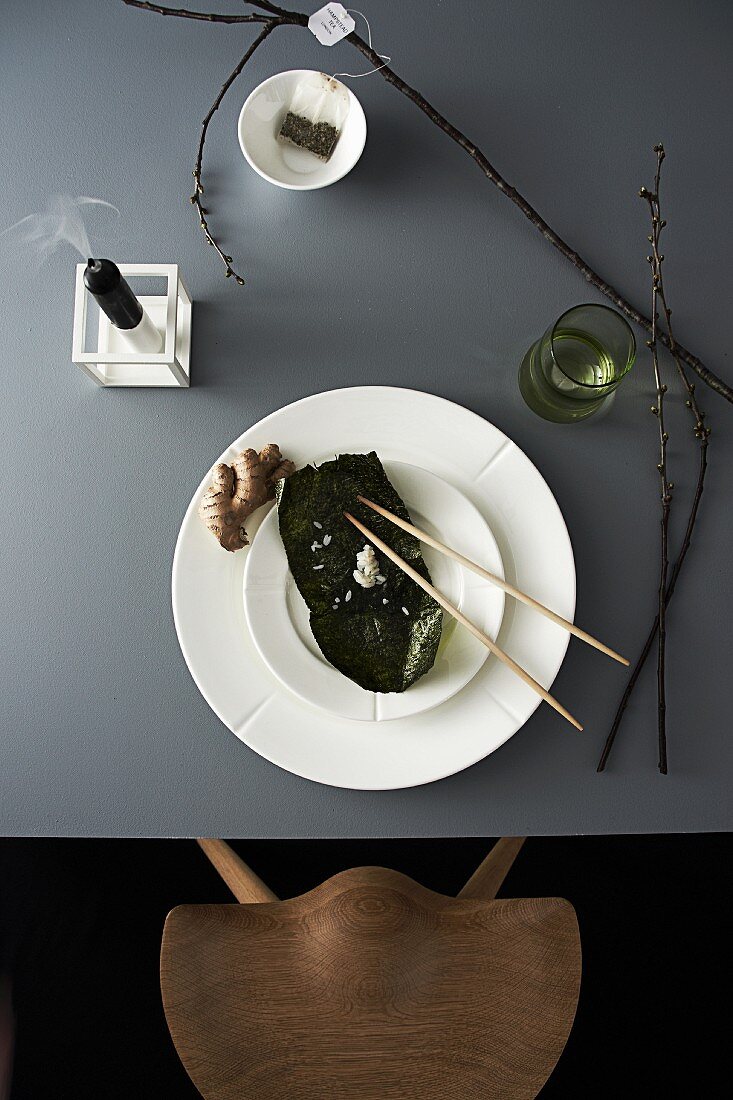 Asiatisch gedeckter Tisch mit Algenblatt, Ingwer und Stäbchen
