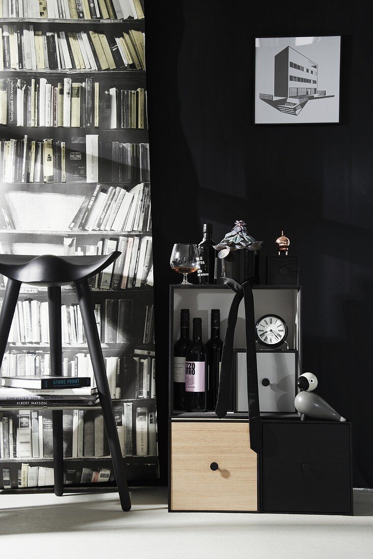 Monochrome interior with drinks cabinet, stool and photo mural of bookcase
