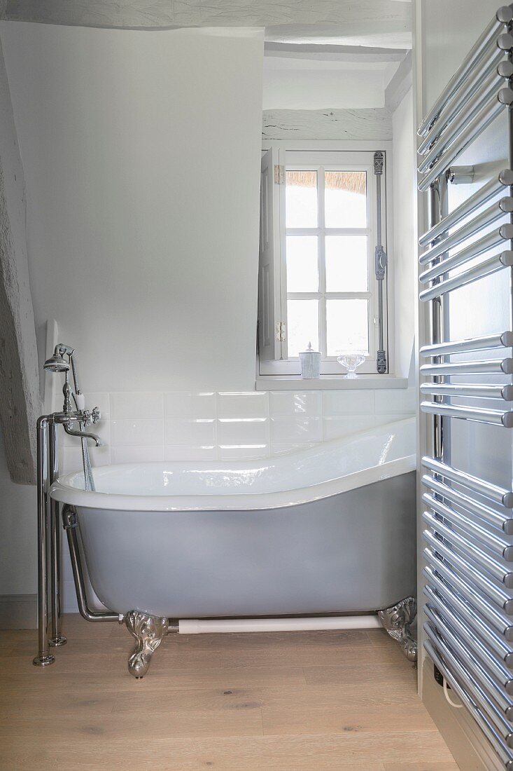 Free-standing bathtub and heated towel rail in farmhouse
