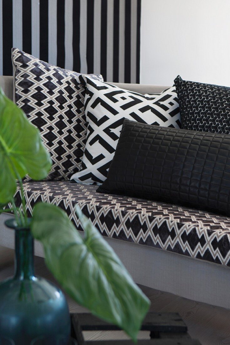 Kissen mit geometrischen, schwarz-weißen Mustern auf Sofa