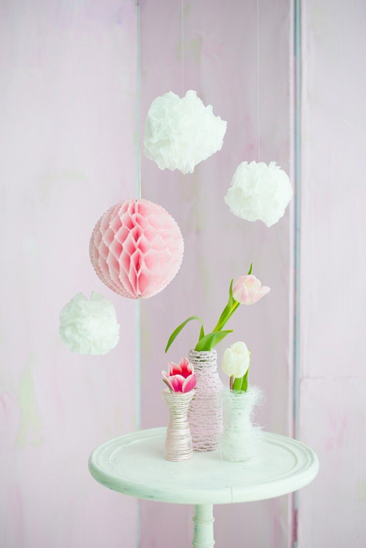 Pompons und Wabenball, umwickelte Vasen mit Tulpen