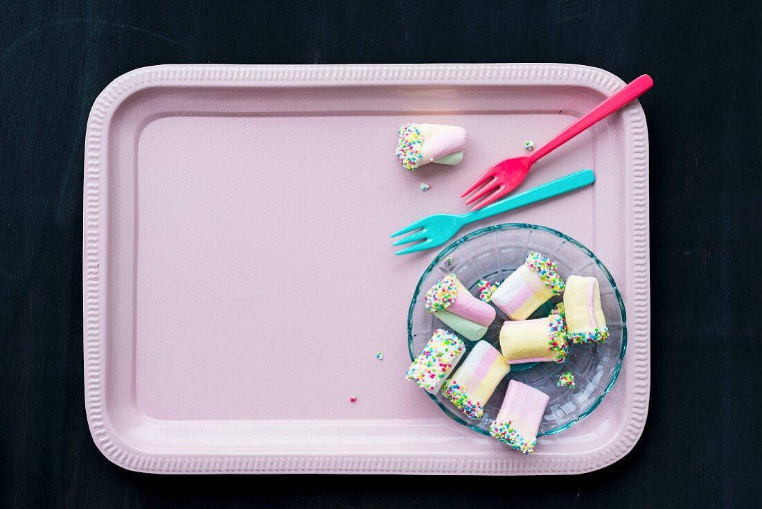 Colourful marshmallows on pink tray