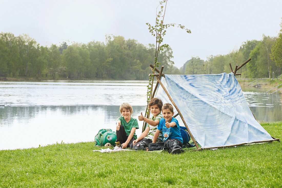Selbst gebautes Zelt am Fluss mit Kindern