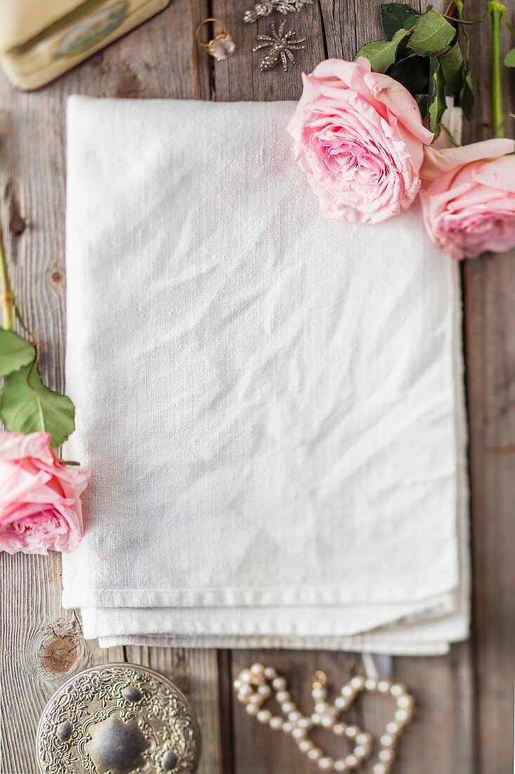 Linen cloth decorated with flowers on wooden surface
