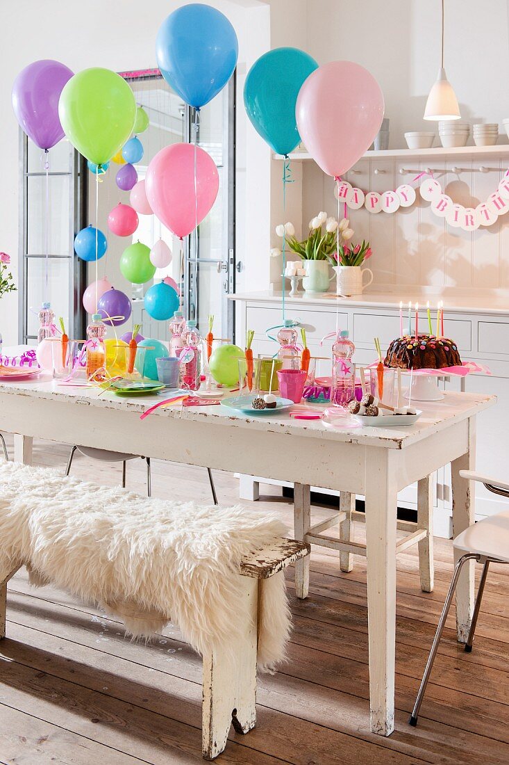 Festlich gedeckter Tisch und bunte Luftballons zum Kindergeburtstag