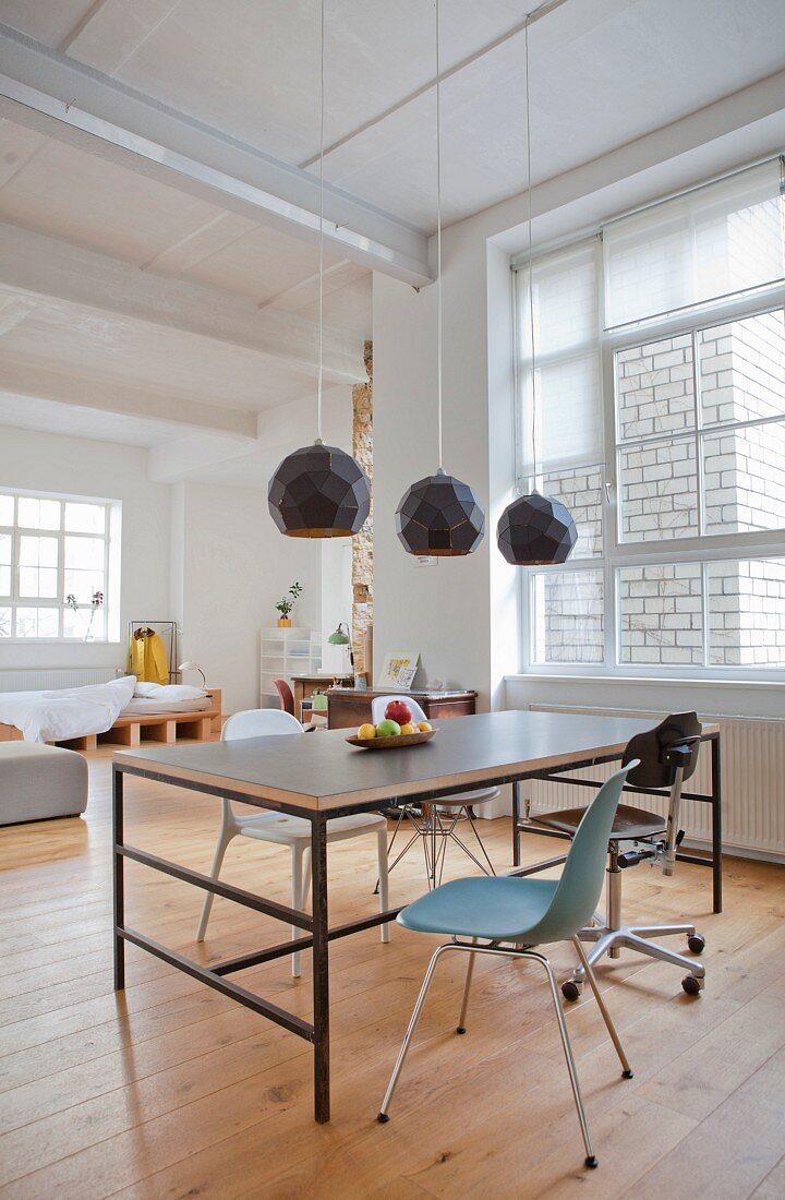 Dining table and various chairs in urban loft apartment