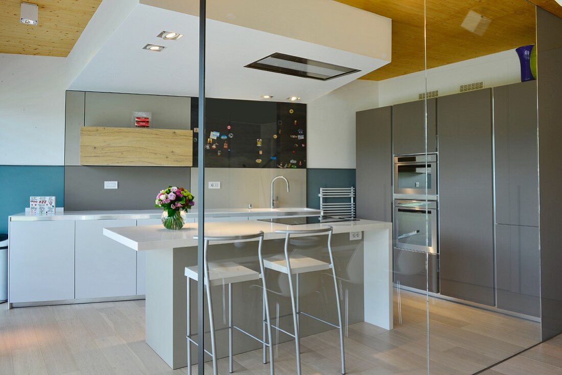 Kitchen counter in elegant minimalist designer kitchen seen through glass partition wall