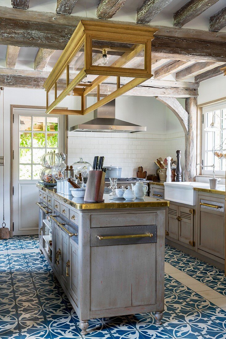 Kücheninsel und blau-weisser Ornamentfliesenboden in Landhausküche