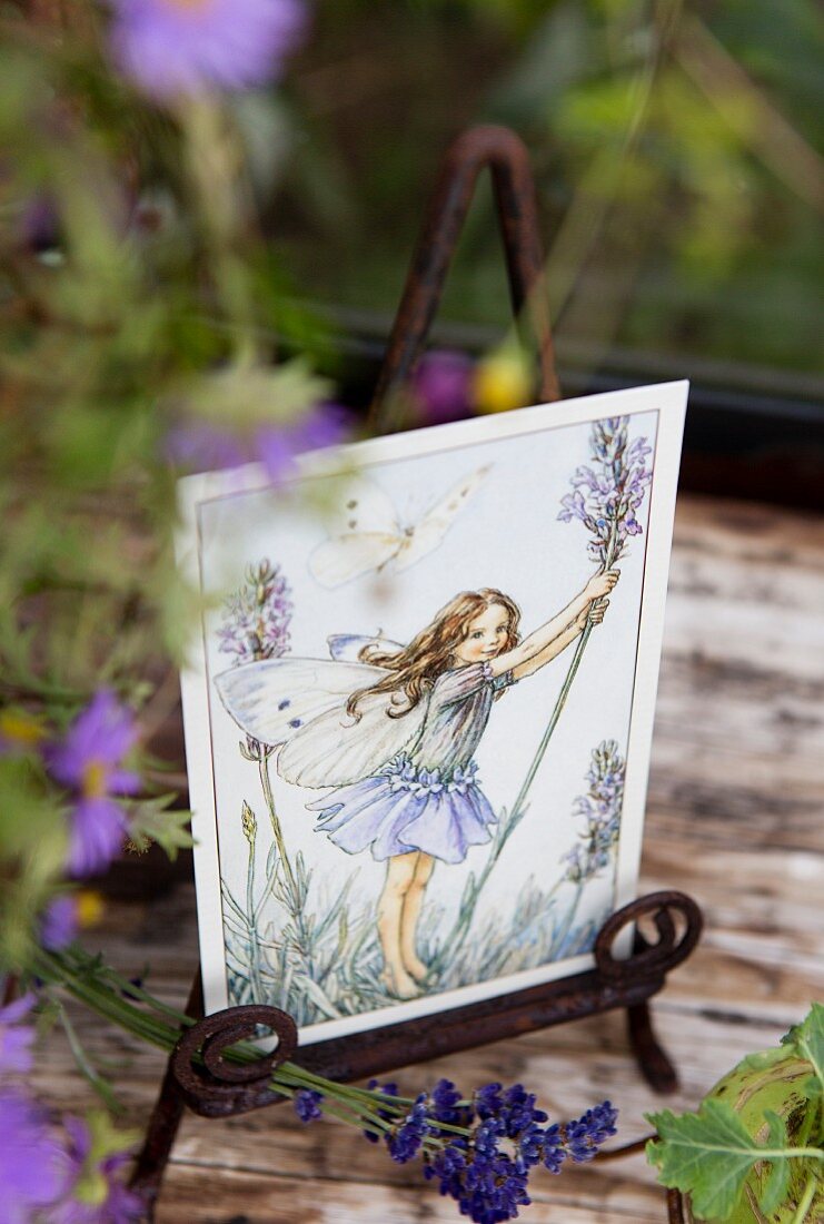Romantic postcard of flower fairy on vintage metal stand decorated with lavender flowers
