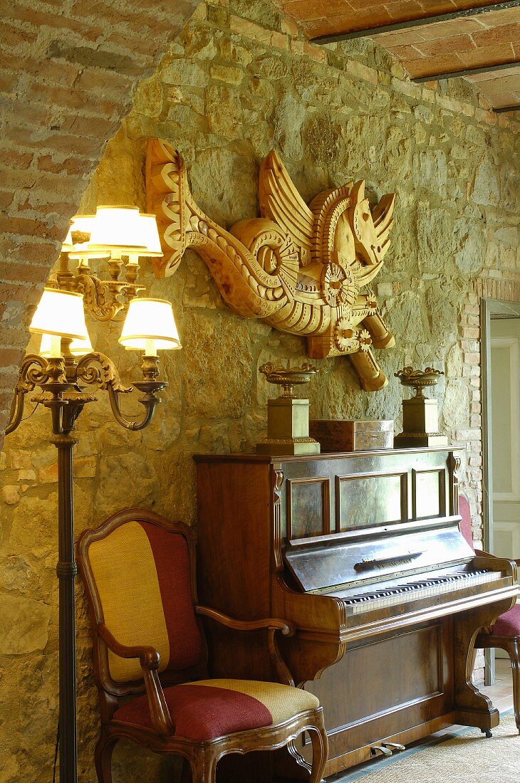 Klavier und Barocksessel vor einer Natursteinwand