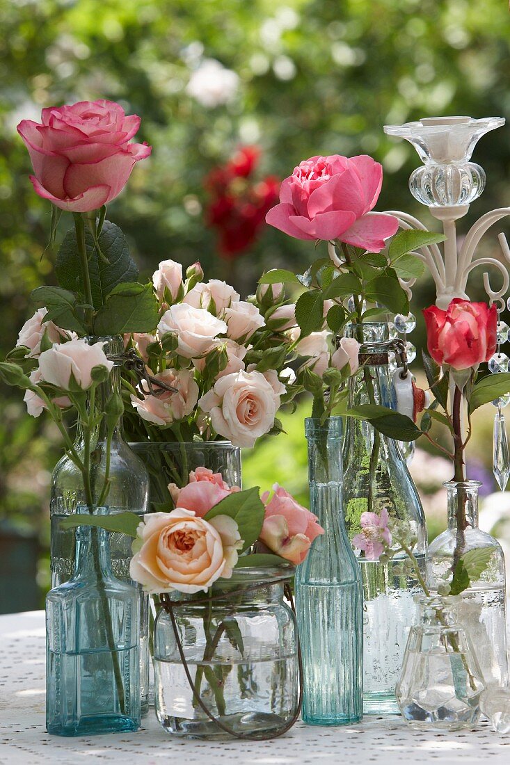 Verschiedene Rosen in einem Vasensammelsurium