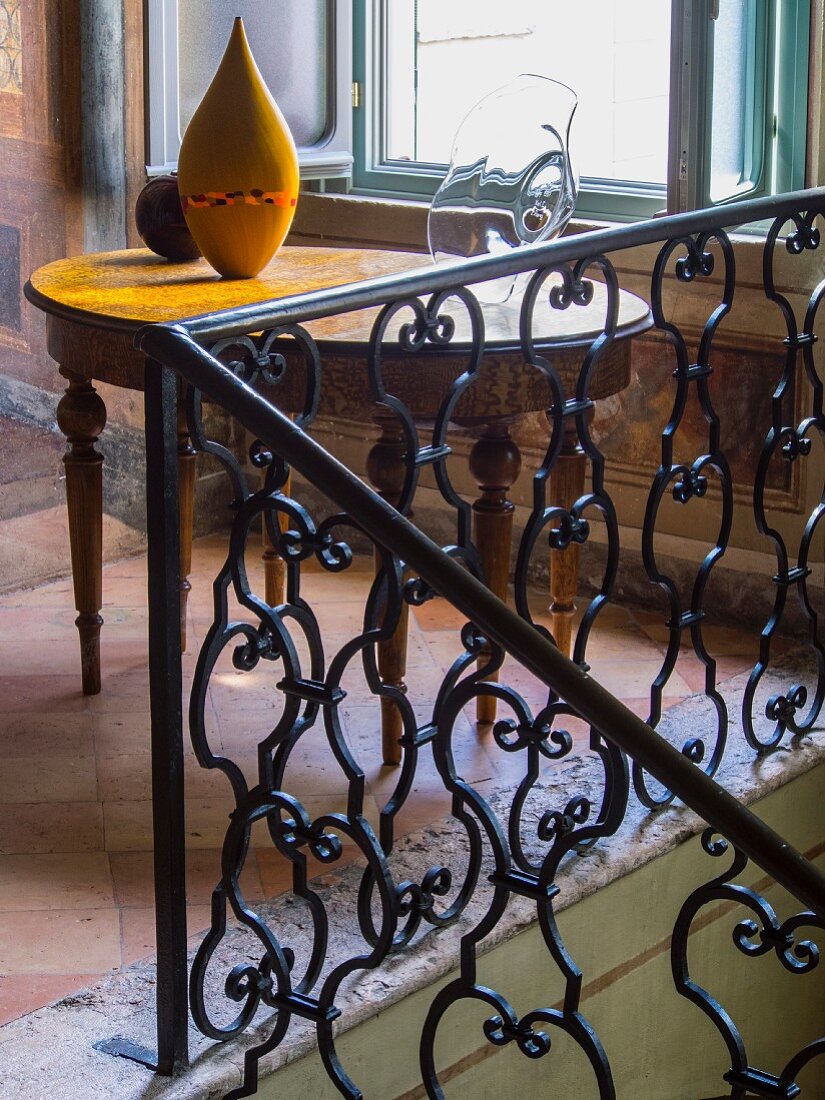 Schmiedeeisernes Geländer in einem Palazzo mit Terrakottafußboden, antiker Holztisch