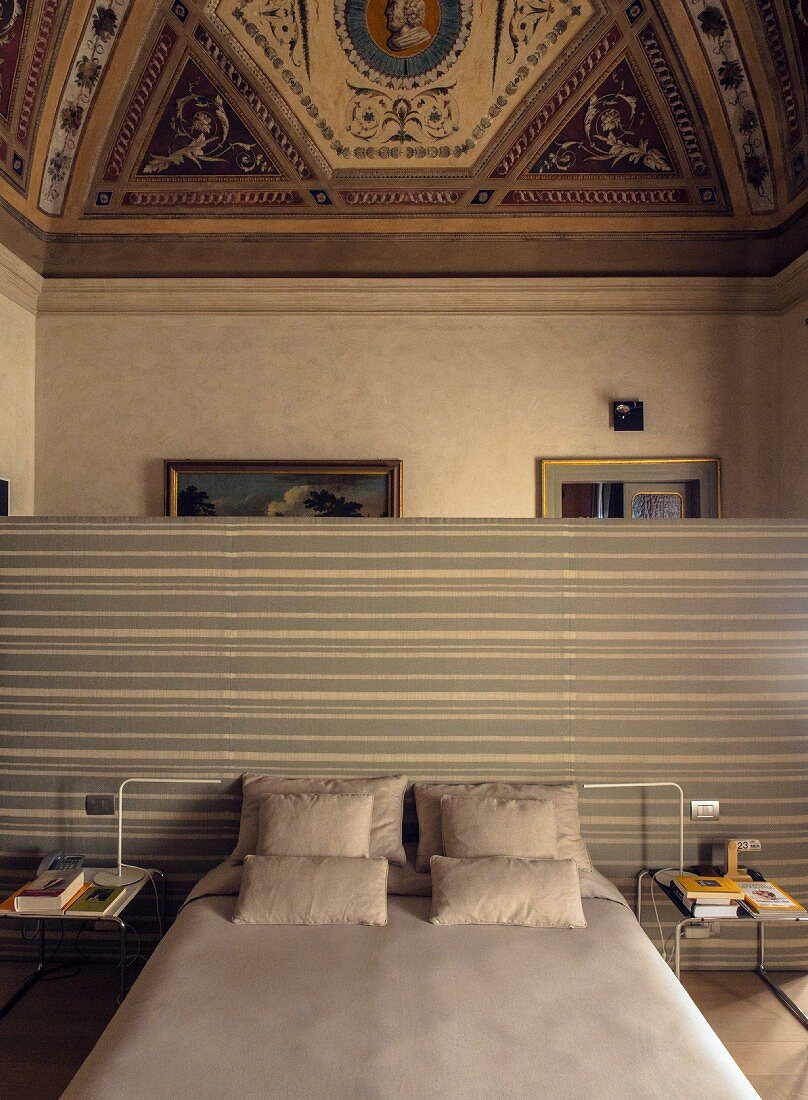Schlafzimmer in einem Palazzo mit hoher, bemalter Decke und eingezogener Trennwand