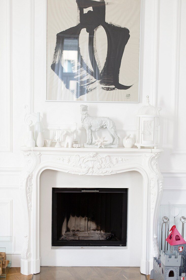 White figurines and painting above fireplace