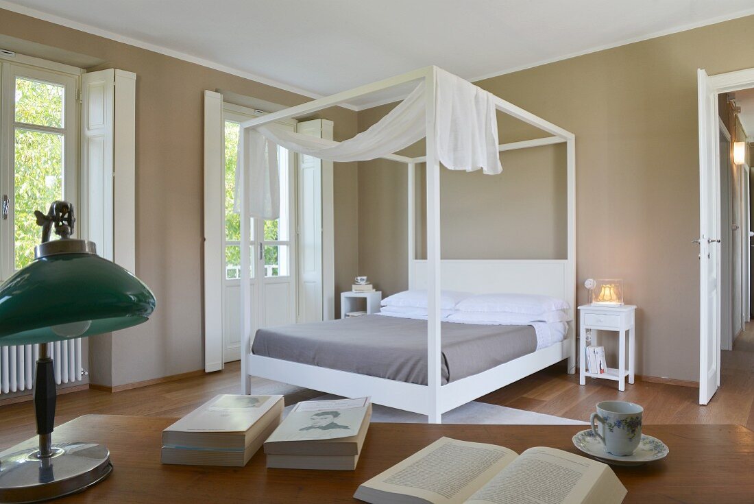 Elegantes Schlafzimmer mit weißem Bettgestell, Baldachin und dunklen Wänden