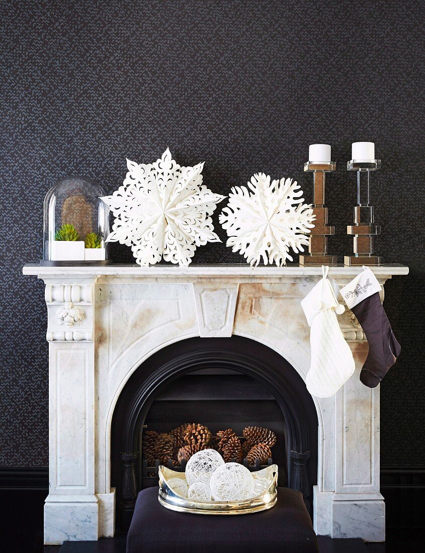 Elegant, Christmas fireplace decoration with paper art and Santa stockings against black textured wallpaper
