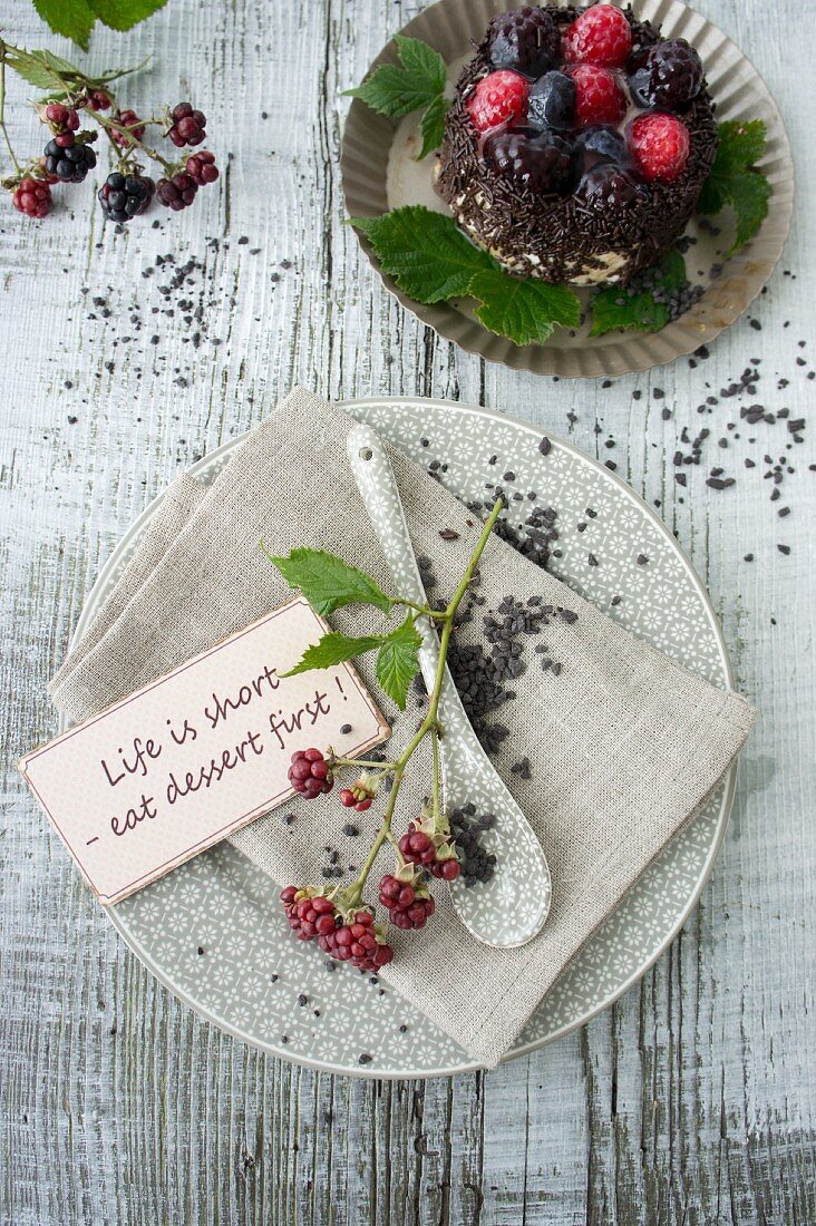 Place setting decorated with blackberries and chocolate caviar