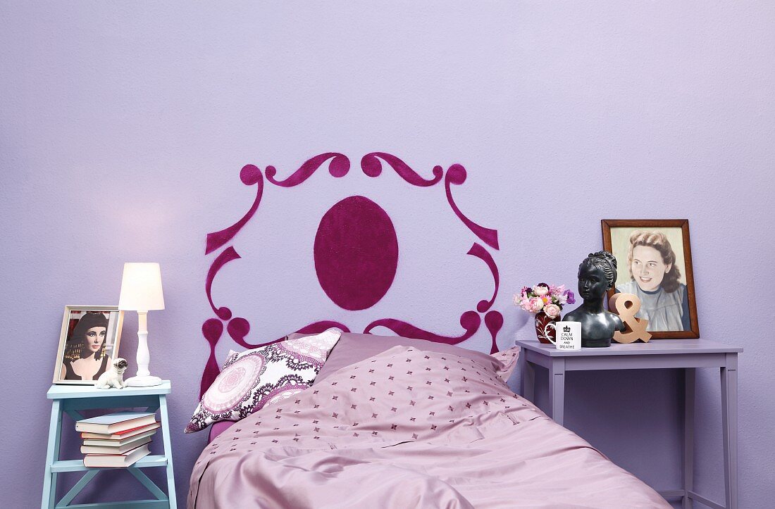 Bed headboard stencilled on wall in purple bedroom