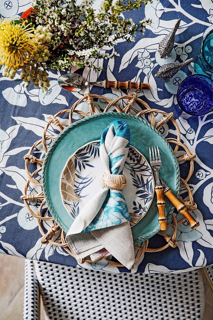 Blautöne und verschiedene florale Muster auf gedecktem Tisch mit maritimem Flair