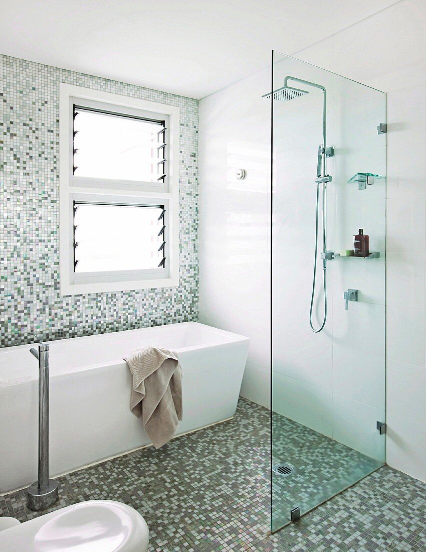 Modernes Bad mit freistehender Wanne, ebenerdiger Dusche und Mosaikfliesen