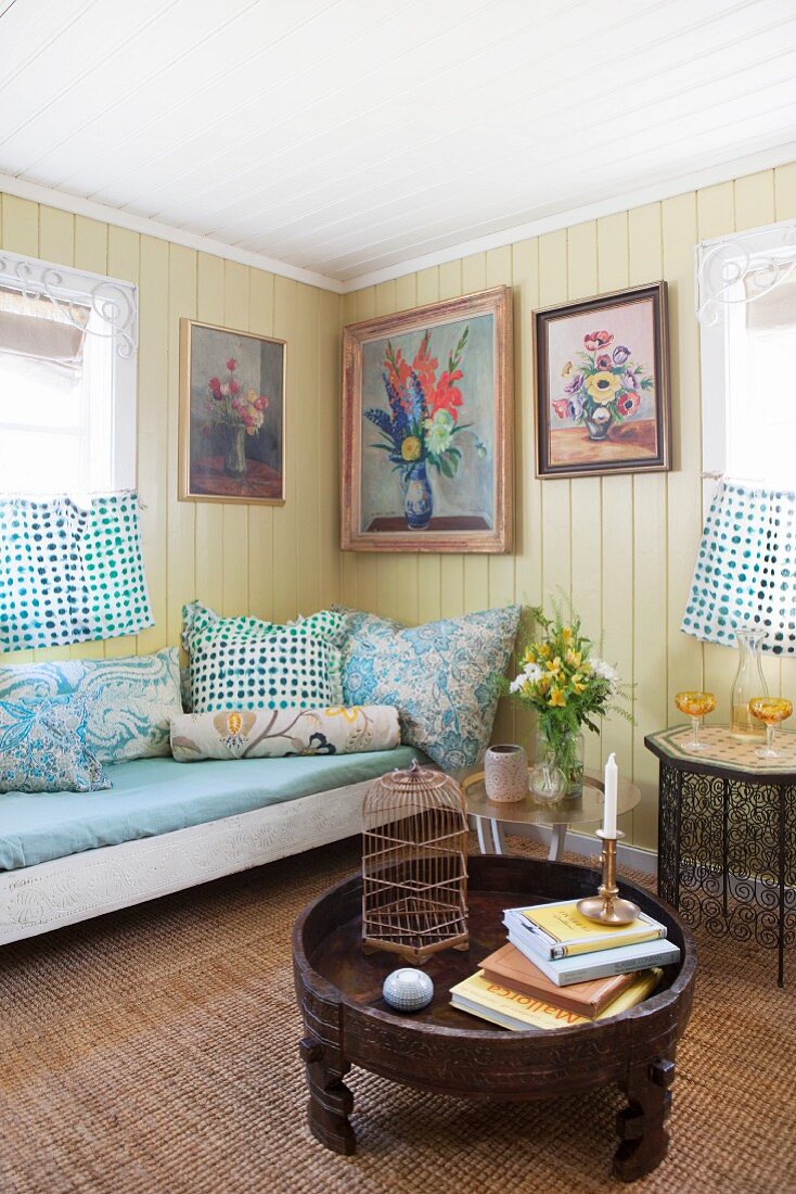 Uriges Wohnzimmer mit gelber Bretterwand und Tagesbett