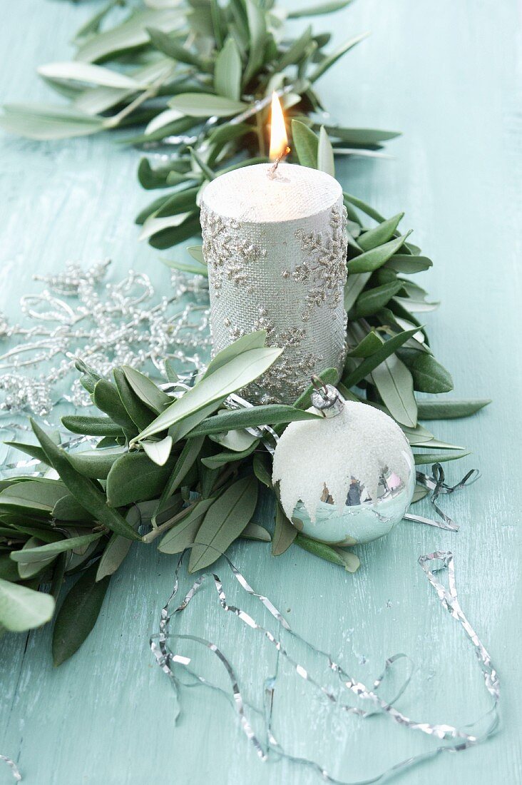 Girlande aus Olivenzweigen mit silberner Kerze, Schneeflocke und Christbaumkugel