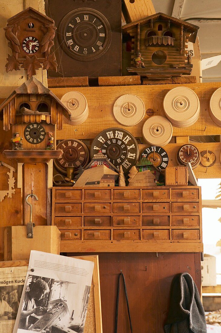 Kuckucksuhren und Zifferblätter in einer traditionellen Werkstatt